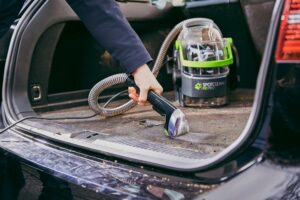 Shampouineuse voiture en action pour le nettoyage coffre et intérieur textile de véhicule.