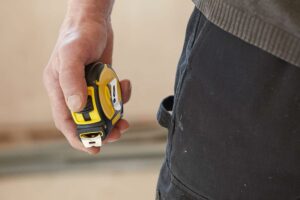 Mètre ruban Stanley 8 mètres utilisé sur chantier, outil essentiel pour des mesures précises à la maison et en rénovation.